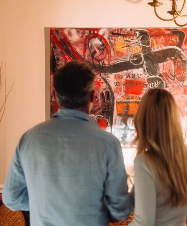 Paar betrachtet Kunstgemälde im Adults Only Design Hotel Cortisen am Wolfgangsee im Salzkammergut