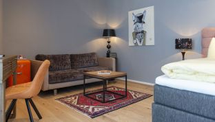 Kunstgemälde bei einer Sitzecke im Doppelzimmer Deluxe mit Bergblick im Designhotel Cortisen am Wolfgangsee
