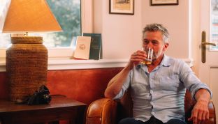 Mann trinkt ein Glas Whiskey in der Billard un Cigar Lounge im Adults Only Boutique Hotel am Wolfgangsee