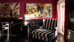 Wohnbereich der Black Suite im Boutiquehotel Cortisen am Wolfgangsee mit moderner Kunst und stilvollem Design