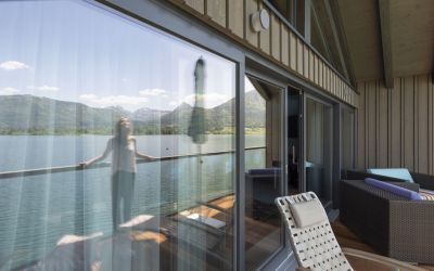 Frau auf Balkon der Bootshaus Suite im 4-Sterne Hotel Cortisen am Wolfgangsee im Salzkammergut