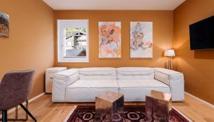 Wohnbereich im Deluxe Zimmer Bergblick im Boutiquehotel Cortisen am Wolfgangsee mit modernem Design, gemütlicher Sitzgelegenheit und hochwertiger Ausstattung