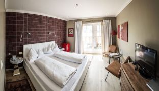 Doppelzimmer mit Bett und Seeblick am Wolfgangsee im Designhotel Cortisen am See
