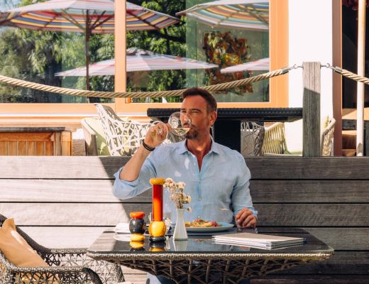 Mann trinkt Wein im 4-Sterne Hotel Cortisen mit Restaurant am Wolfgangsee