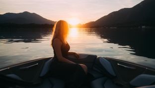 Frau bei einer Bootstour vom Boutique Hotel Cortisen auf dem Wolfgangsee bei Sonnenuntergang