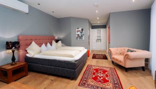 Modernes Deluxe Zimmer mit Bergblick im Boutiquehotel Cortisen am Wolfgangsee mit Klimaanlage, stilvollem Interieur und komfortablem Wohnbereich