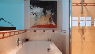 Badewanne und Dusche in der Loft Suite im Boutiquehotel Cortisen am Wolfgangsee mit modernem Design und hochwertiger Ausstattung