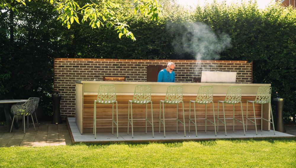 Mann kocht in Outdoorküche im Sommer im Gourmet Restaurant Cortisen am Wolfgangsee