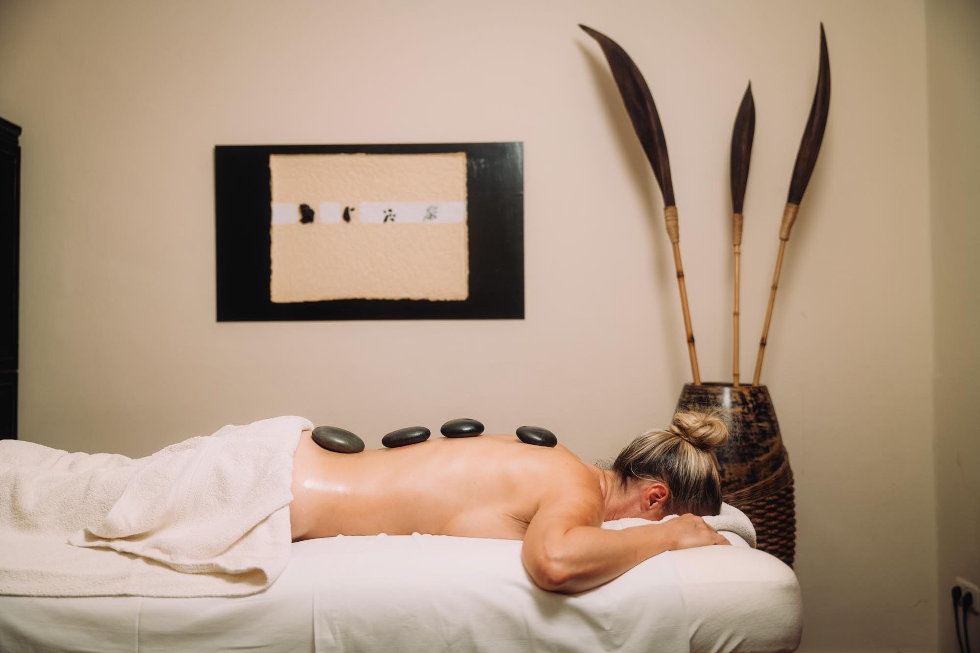 Frau bei einer Hot Stone Massage im 4-Sterne Spa Hotel Cortisen am Wolfgangsee im Salzkammergut