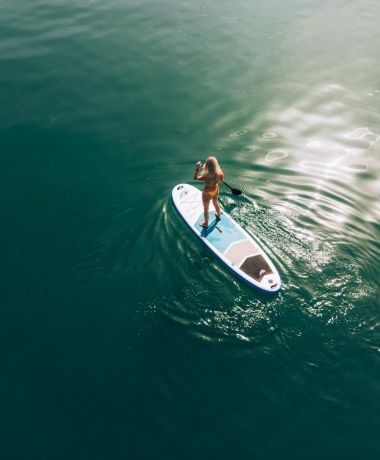 Frau fährt Stand Up Paddle Board auf dem Wolfgangsee im Boutique Hotel Cortisen am See