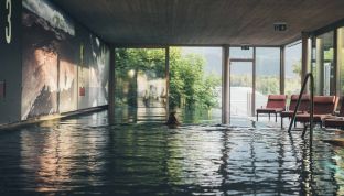 Frau schwimmt im Pool im Designhotel Cortisen am Wolfgangsee