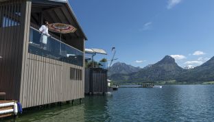 Frau auf Balkon des Bootshaus vom Adults Only Hotel direkt am Wolfgangsee