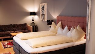 Hochwertiges Bett im Deluxe Zimmer Bergblick im Boutiquehotel Cortisen am Wolfgangsee mit modernem Design und gemütlichem Schlafkomfort