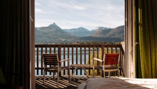 Balkon des Deluxe Zimmers Seeblick im Boutiquehotel Cortisen am Wolfgangsee mit direktem Blick auf den Wolfgangsee und gemütlicher Sitzgelegenheit