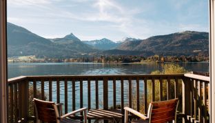 Balkonmöbel des Deluxe Zimmers Seeblick im Boutiquehotel Cortisen am Wolfgangsee mit freiem Blick auf den See und die umliegenden Berge