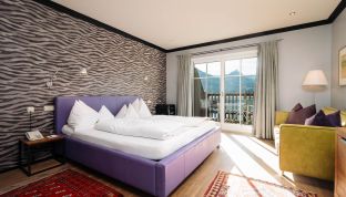 Deluxe Zimmer Seeblick im Boutiquehotel Cortisen am Wolfgangsee mit auffälliger Designtapete, modernem Interieur und stilvoller Atmosphäre