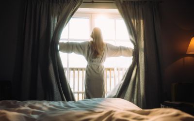 Frau genießt den Blick aus ihrem Zimmer im Designhotel Cortisen am Wolfgangsee