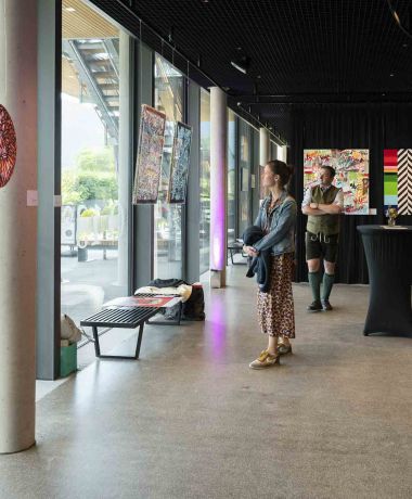 Menschen begutachten Kunst Gemälde beim Art Circle am Wolfgangsee im Designhotel Cortisen am See