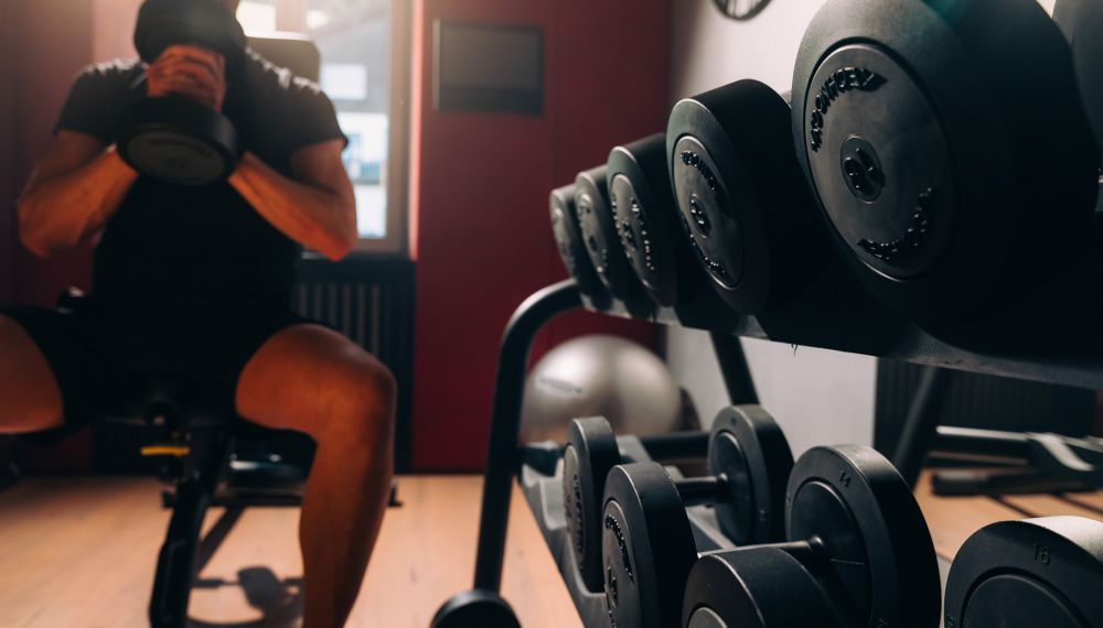 Mann trainiert im Fitnessstudio im Adults Only Hotel Cortisen am Wolfgangsee