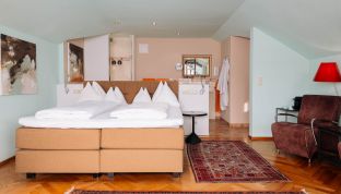 Zimmeransicht der Loft Suite im Boutiquehotel Cortisen am Wolfgangsee mit modernem Interieur, hochwertigem Design und großzügigem Raumgefühl
