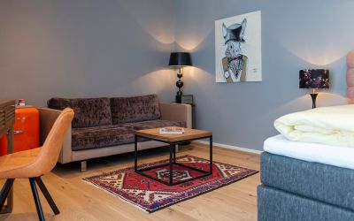 Sitzbereich mit Couch und Tisch im Zimmer des Designhotels Cortisen am Wolfgangsee im Salzkammergut