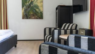 Sitzecke mit gestreiften Sesseln im Standard Doppelzimmer im Boutique Hotel Cortisen am Wolfgangsee