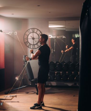 Mann trainiert im Fitnessstudio im Aktivhotel Cortisen am Wolfgangsee in Österreich