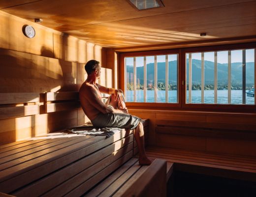 Mann genießt Sauna mit Seeblick am Wolfgangsee im Hotel Cortisen