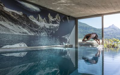 Mann springt in den Pool mit Seeblick im Hotel Cortisen am Wolfgangsee