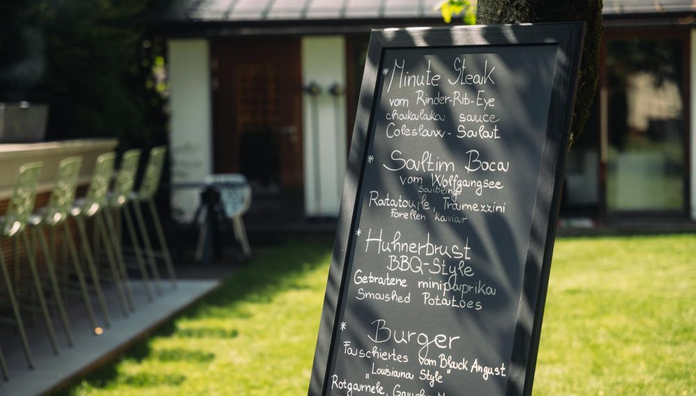 Tafel mit Speisekarte im Garten des Boutqie Hotels Cortisen am Wolfgangsee