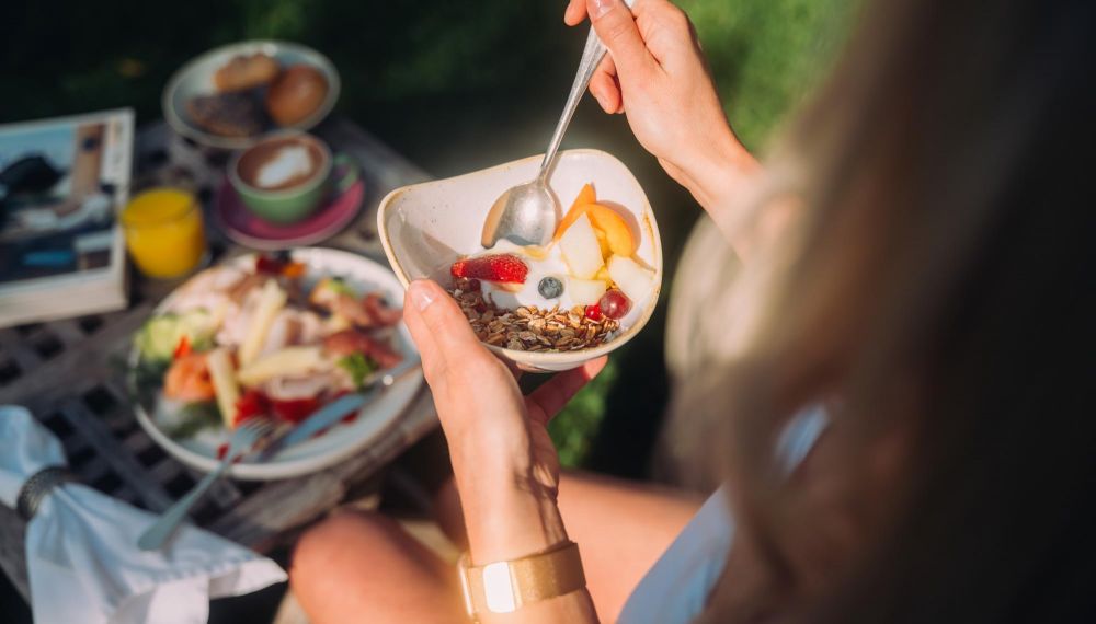 Frau isst Müsli beim Luxus Frühstück am Wolfgangsee im Boutique Hotel Cortisen am Wolfgangsee