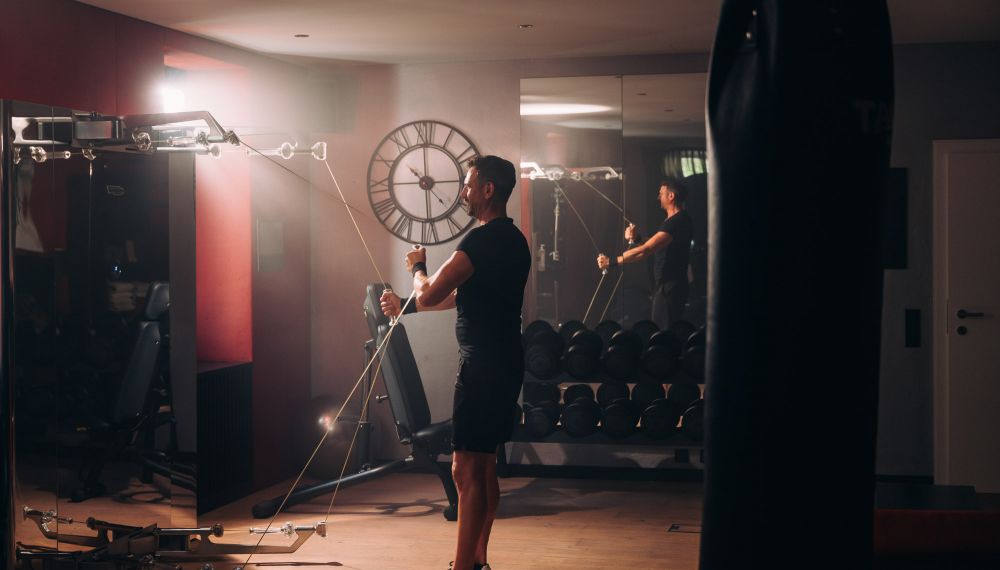 Mann trainiert im Fitnessstudio im Aktivhotel Cortisen am Wolfgangsee in Österreich