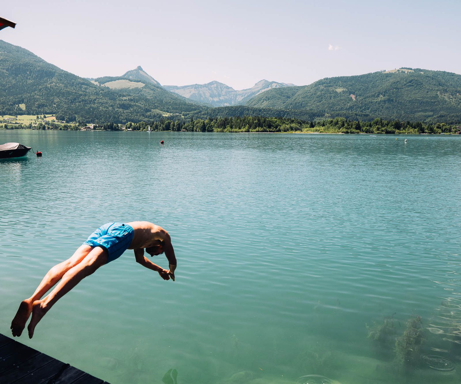 Mann springt in den Wolfgangsee vom Boutique Hotel Cortisen im Salzkammergut aus