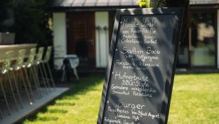 Tafel mit Speisekarte im Garten des Boutqie Hotels Cortisen am Wolfgangsee