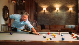 Mann spielt Billard im Adults Only Hotel Cortisen am Wolfgangsee