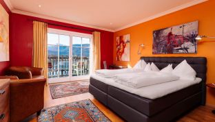 Deluxe Zimmer Seeblick im Boutiquehotel Cortisen am Wolfgangsee mit modernem Interieur, gemütlichem Schlafbereich und direktem Zugang zum Balkon