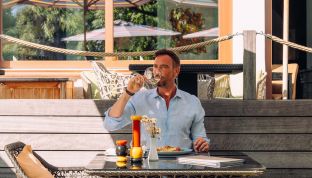 Mann trinkt Wein im 4-Sterne Hotel Cortisen mit Restaurant am Wolfgangsee