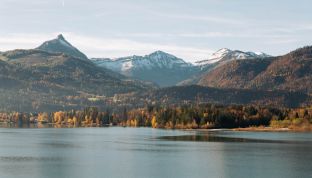 Aussicht aus der Loft Suite im Boutiquehotel Cortisen am Wolfgangsee mit herbstlicher Landschaft, goldenem Laub und Blick auf See und Berge
