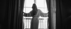 Frau steht am Fenster im Zimmer des 4-Sterne Boutique Hotels Cortisen am Wolfgangsee