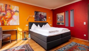 Deluxe Zimmer Seeblick im Boutiquehotel Cortisen am Wolfgangsee mit warmen Farbtönen, modernen Kunstwerken und stilvollem Interieur