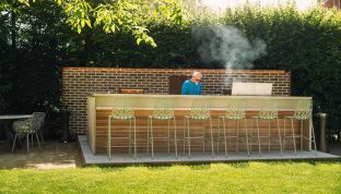 Mann kocht in Outdoorküche im Sommer im Gourmet Restaurant Cortisen am Wolfgangsee