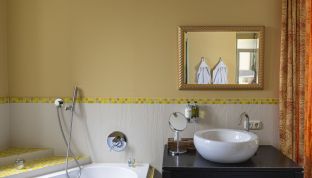Badezimmer mit gelben Mosaik in der Terrassen Suite mit Seeblick im Boutiquehotel Cortisen am Wolfgangsee