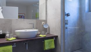 Waschbecken und Dusche im Deluxe Zimmer mit Bergblick im Hotel Cortisen am Wolfgangsee