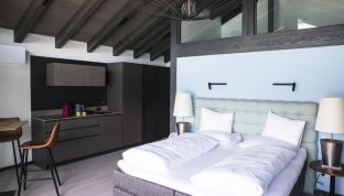 Doppelbett in der Bootshaus Suite im Designhotel Cortisen mit Seeblick