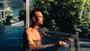 Mann im Infinity Pool im Spa Hotel Cortisen am Wolfgangsee