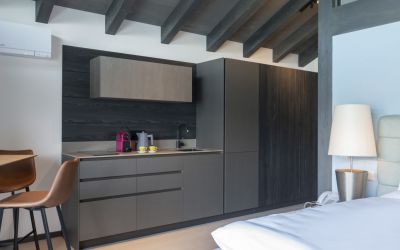 Küchenzeile, Esstisch und Bett in einem Zimmer des Designhotels Cortisen am See