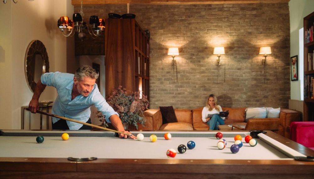 Mann spielt Billard in der Lounge im Boutique Hotel am Wolfgangsee