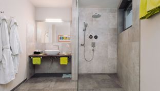 odernes Badezimmer im Deluxe Zimmer Bergblick im Boutiquehotel Cortisen am Wolfgangsee mit hochwertiger Ausstattung und stilvollem Design