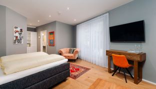 Deluxe Zimmer mit Bergblick im Boutiquehotel Cortisen am Wolfgangsee mit modernem TV, hochwertigem Interieur und gemütlichem Schlafbereich