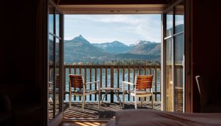 Blick aus dem Deluxe Zimmer Seeblick im Boutiquehotel Cortisen am Wolfgangsee auf den Balkon mit freier Aussicht auf den See und die umliegenden Berge